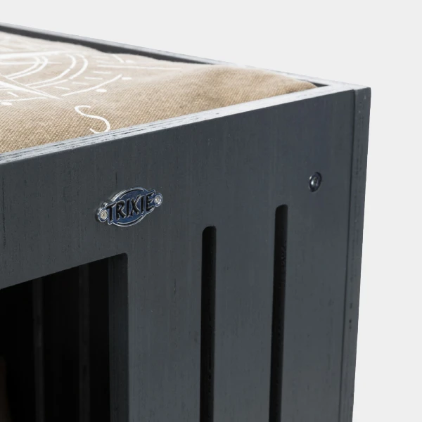 Primer plano de cueva de madera para perros con emblema de marca visible y tapa de cojín de diseño superior, destacando la calidad y estilo del producto