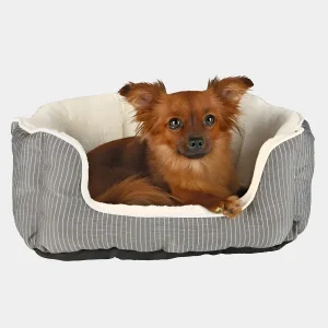 Cama para Mascotas Pequeñas en Diseño Moderno y Confortable Pequeño perro marrón descansando en una cama para mascotas pequeñas con diseño de rayas grises y borde de felpa blanca, proporcionando comodidad y seguridad