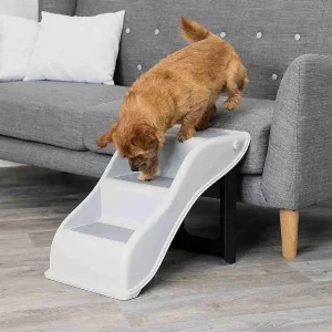 Perro pequeño utilizando una escalera para perros para subir a la cama, mostrando la facilidad de acceso y seguridad del producto