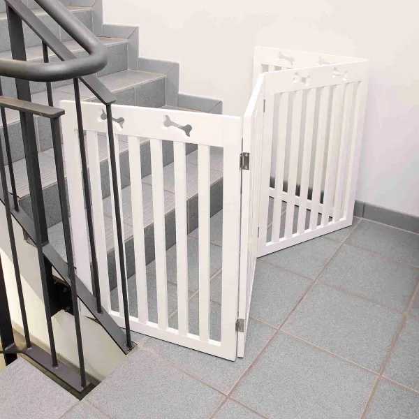 Puerta de seguridad blanca para perros grandes con diseño ajustable, instalada en la base de una escalera para restringir el acceso