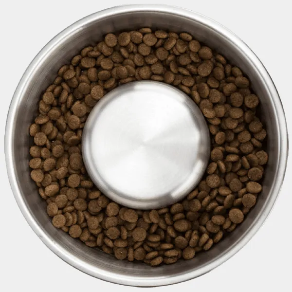 Vista superior de un comedero antivoracidad para perros lleno de croquetas, diseñado para ralentizar la ingesta de comida y promover una mejor digestión