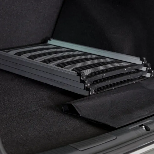 Rampa Trixie telescópica para perros plegada y almacenada en el maletero de un coche, mostrando su conveniencia y diseño que ahorra espacio