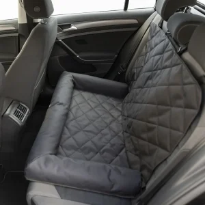 Asiento de coche para perros grandes instalado en el asiento trasero, de color gris acolchado, destacando su diseño seguro y cómodo para viajar con mascotas grandes