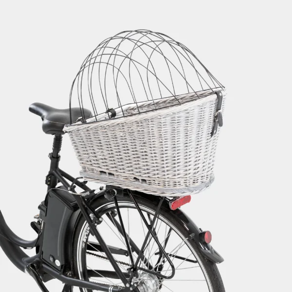 Canasto de mimbre gris para bicicleta adaptado para perros con rejilla de seguridad negra, mostrando la cesta acoplada a la parte trasera de una bicicleta
