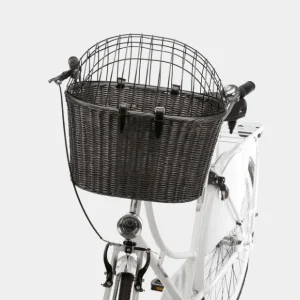 Canasta para transportar perros en bicicleta de mimbre sintético negro con rejilla de protección, montada en la parte frontal de una bicicleta blanca.