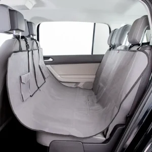 Funda cubreasientos para perros de color gris extendida sobre el asiento trasero de un vehículo, mostrando cobertura completa y bolsillos integrados para almacenamiento