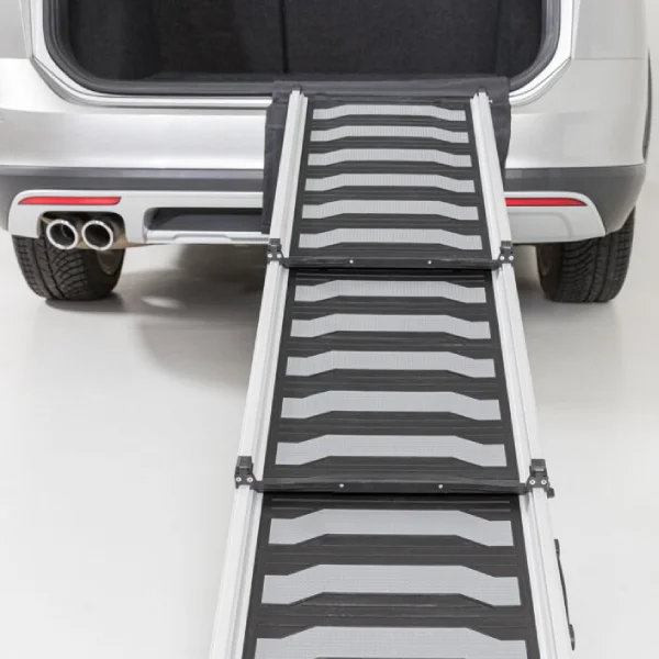 Rampa para perros Trixie desplegada desde el maletero de un coche, mostrando su superficie antideslizante y construcción robusta para la seguridad de las mascotas