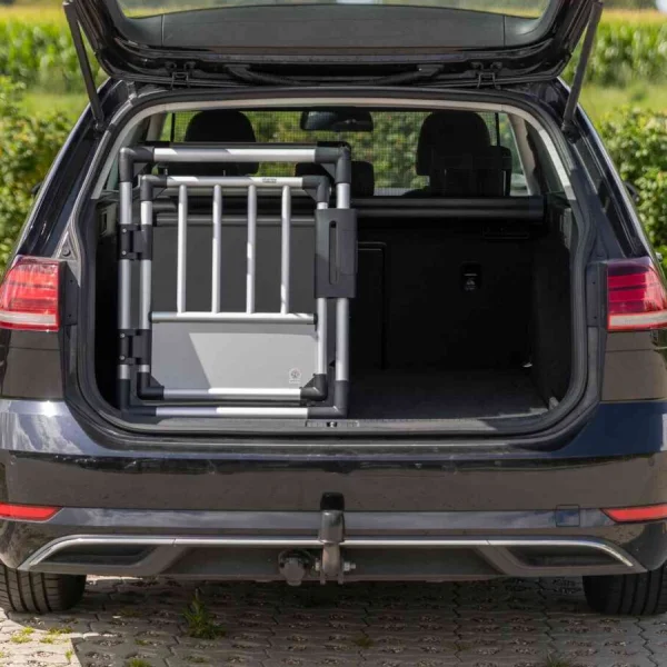Transportín de aluminio para coches colocado en el maletero de un vehículo, mostrando el ajuste perfecto y la optimización del espacio para el transporte seguro de mascotas.