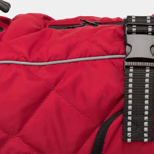 Primer plano de la hebilla ajustable y las bandas reflectantes en la capa de invierno para perros en color rojo, destacando la calidad del material y la seguridad para paseos nocturnos