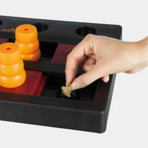 Coloca golosinas en el juguete interactivo para perros y estimula su mente Mano colocando una golosina en el juguete interactivo para perros con conos y piezas deslizantes, diseñado para mejorar las habilidades cognitivas y mantener a las mascotas entretenidas