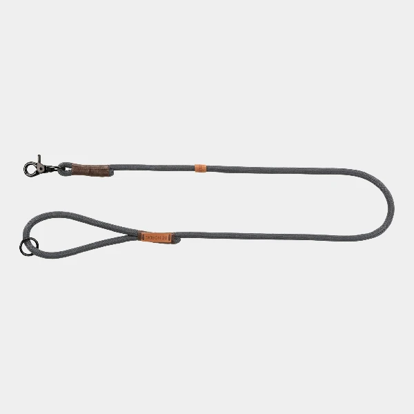 Correa corta para perros TRIXIE en color gris, con detalles en cuero marrón y enganche de gatillo, ideal para un control seguro y cómodo durante los paseos