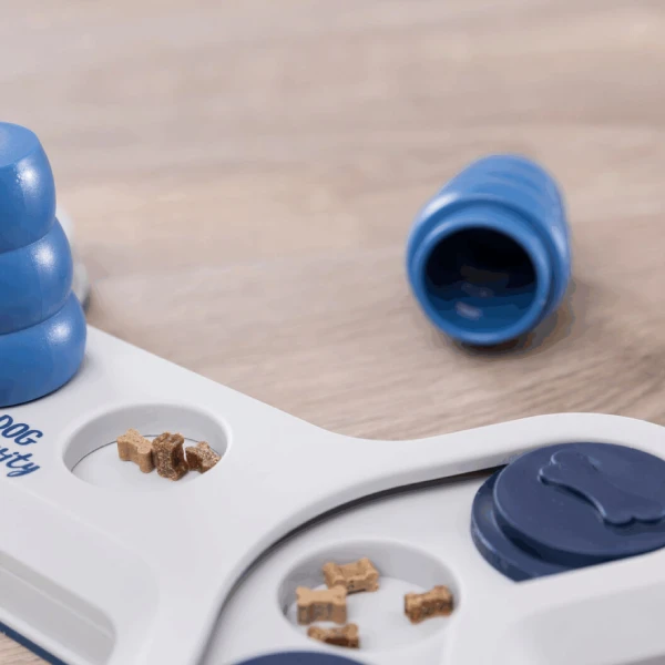 Primer plano de un juego inteligente para perros, mostrando compartimentos deslizantes y conos azules para ocultar premios