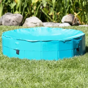 Cubierta para piscina de perros en color azul claro instalada en un jardín, protegiendo el agua de suciedad y desechos