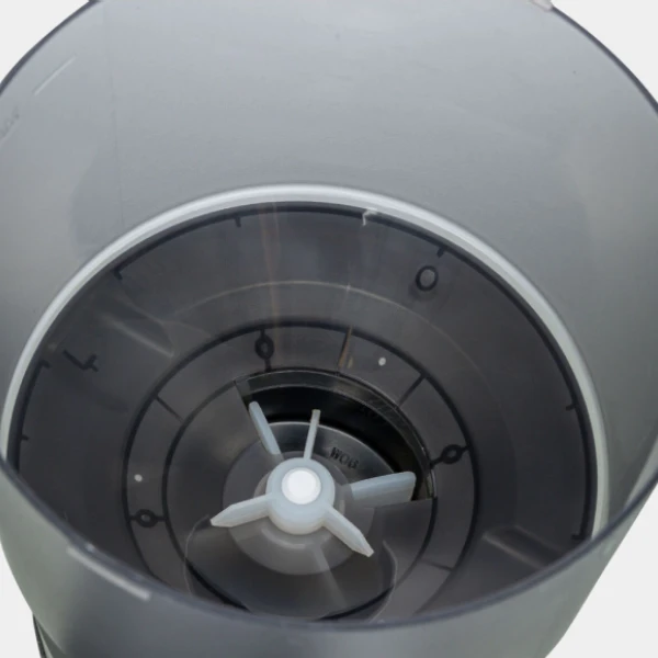 Vista interior de un dispensador de comida para perros, mostrando el mecanismo de distribución y las marcas de medición del contenedor.