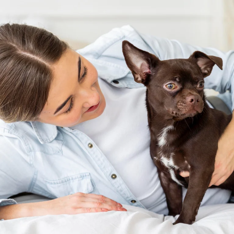 Mujer acariciando a su perro con mirada triste, mostrando cuidado y apoyo durante un episodio de depresión postvacacional canina